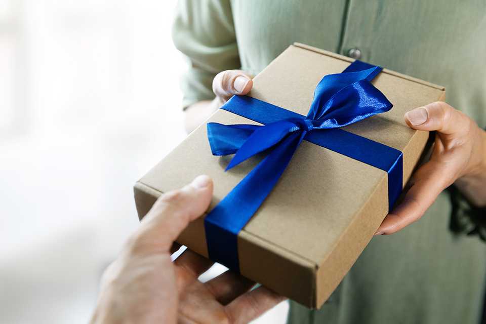 A woman gifting her partner a present.