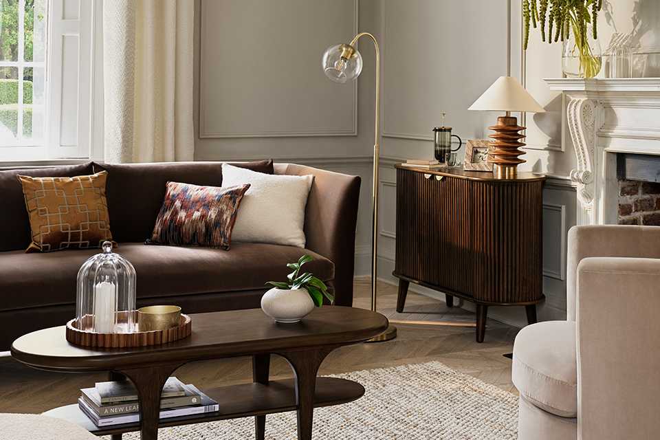 Habitat modern luxury living room showcasing wooden finish sideboard, TV unit and a brown velvet sofa along with other homeware accessories.