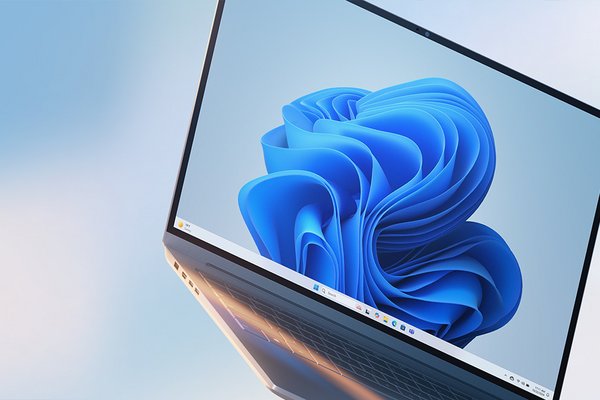 A silver Microsoft Windows 11 PC displayed against a light blue background.