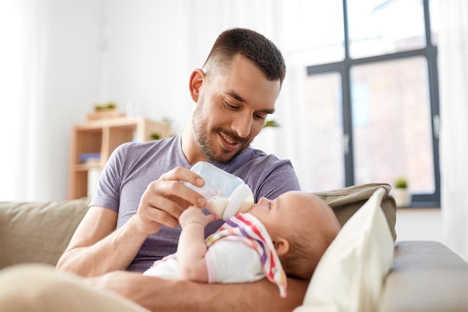 Father feeding baby daughter from bottle.