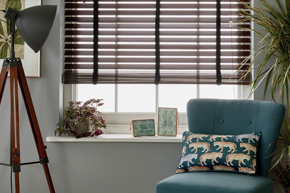 Living room with wooden venetian blinds and blue armchair.