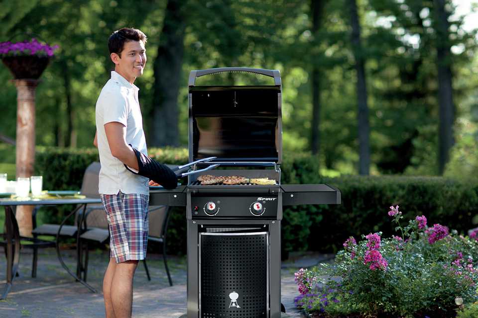 A man grilling food on a BBQ in a garden.