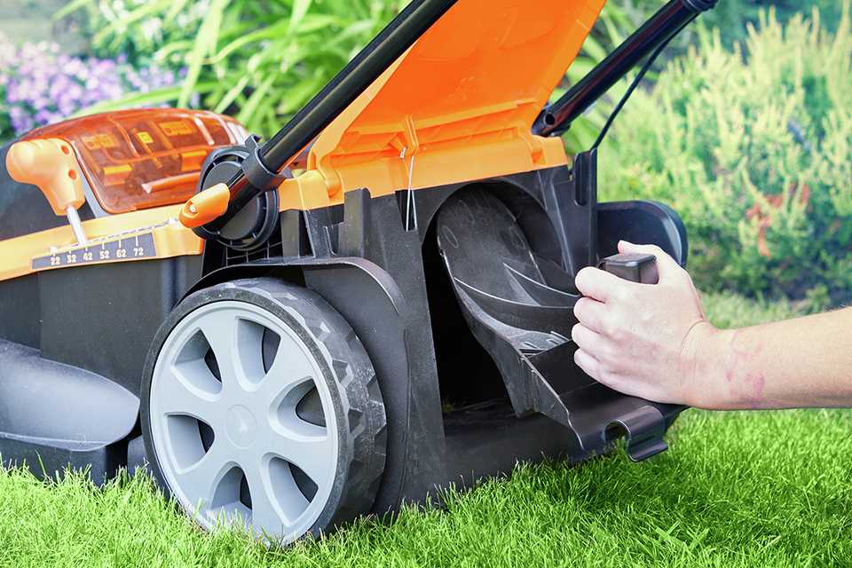 A man using LawnMaster 41Cm cordless rotary lawnmower with a grass box and mulcher.