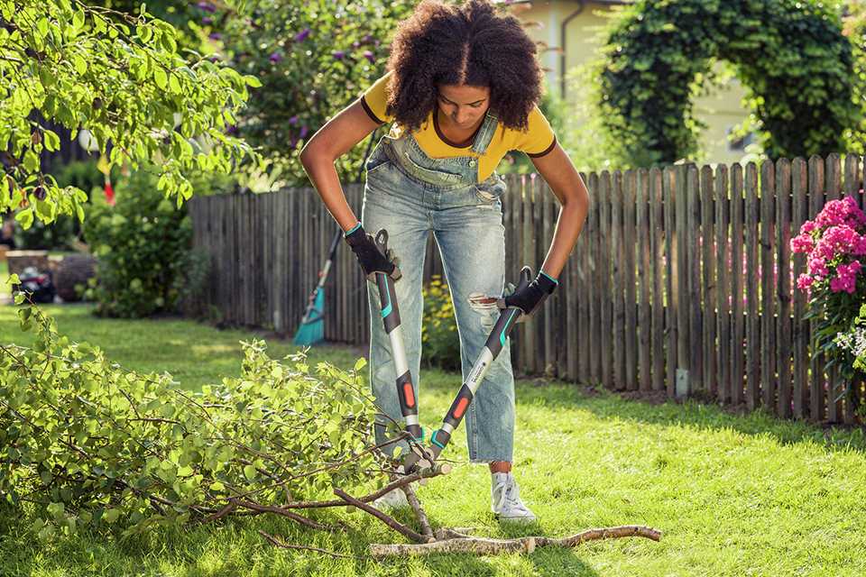 A woman using Gardena Telescopic pruning lopper.