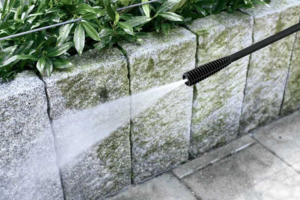 A close up image of Karcher K 2 Classic Pressure Washer being used on a patio.