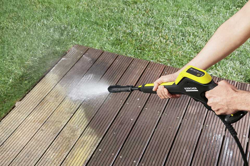 A person using the 2100W Karcher K5 Power Control Car & Home Pressure Washer to clean the patio.