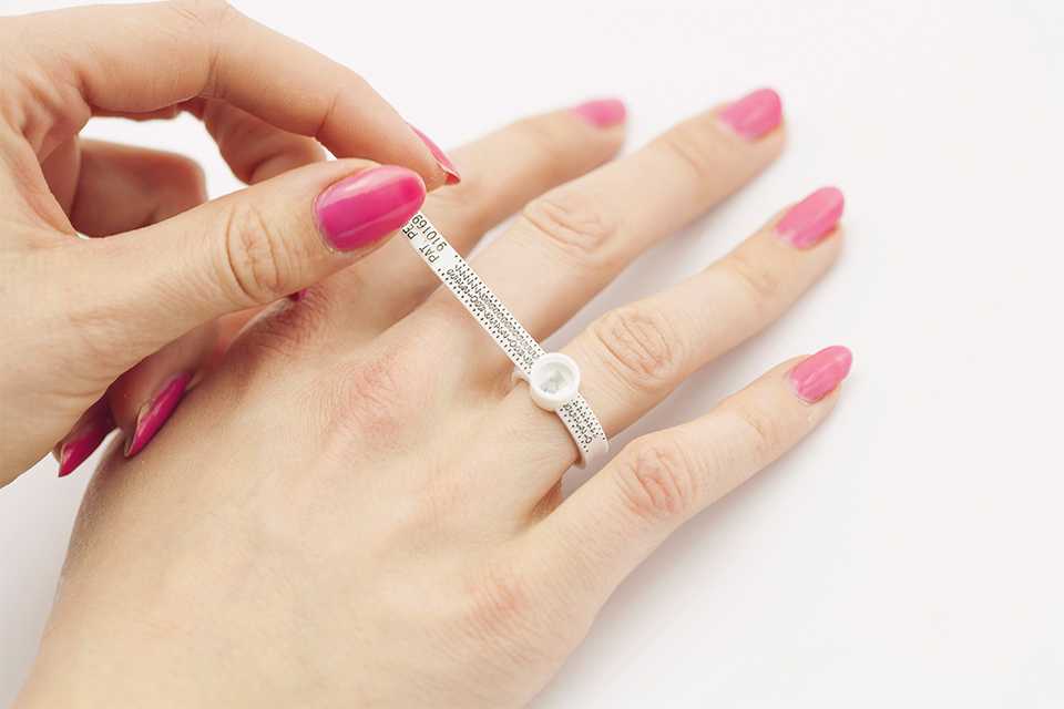 A woman measuring her finger for a ring.