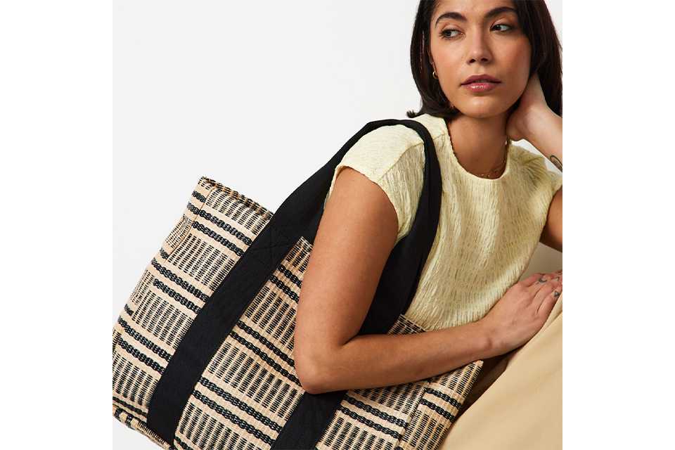 Summer accessories styled with a textured sleeveless top and woven bag, adding interest to a warm‑weather outfit.