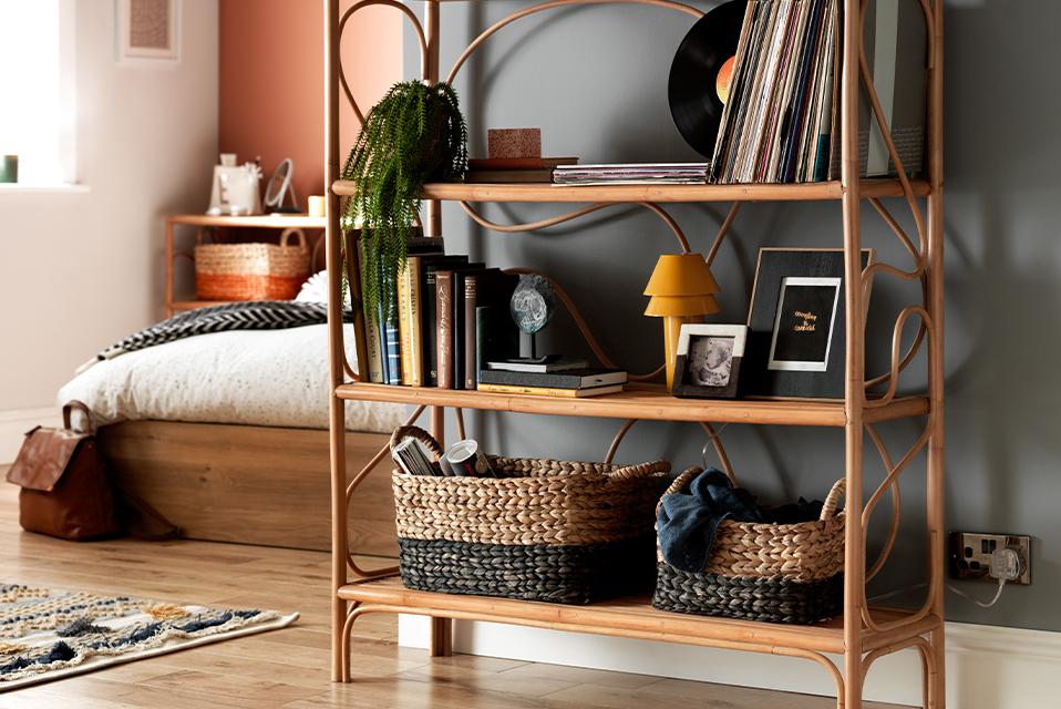 A steam-bent wooden bookcase with boho vibes decorated with vases, plants, and vinyl records.
