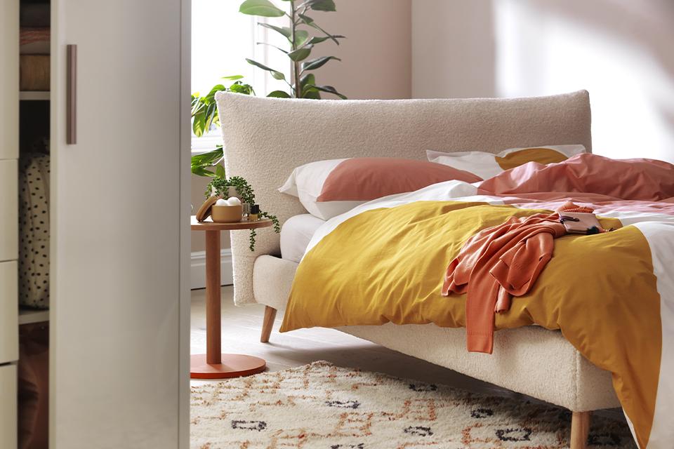 A pastel shade bedroom with a matching upholstered bed.