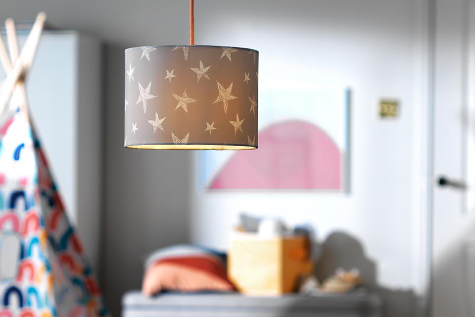 Image of a grey and white star fabric lampshade in a kids' bedroom.