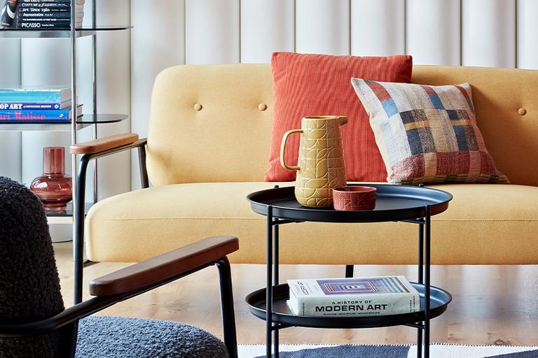Living room with mid-century yellow sofa and orange armchair.