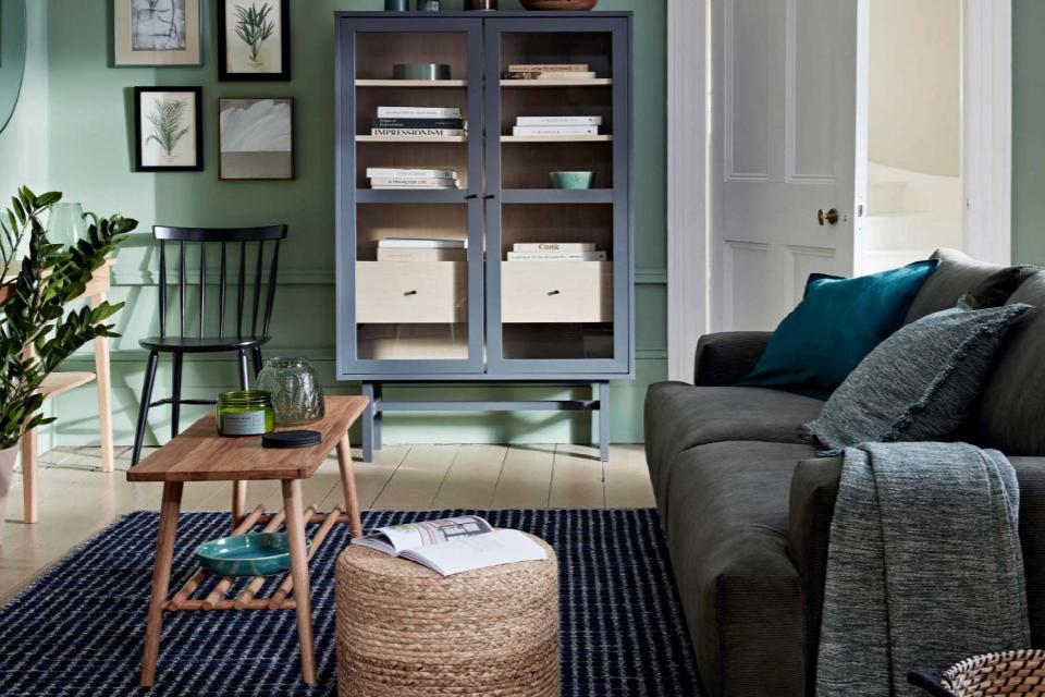 Modern country style living room with glass cabinet, grey sofa and wooden coffee table.
