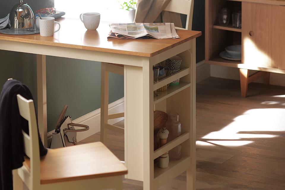 Dining table with inbuilt storage shelves and two stools.