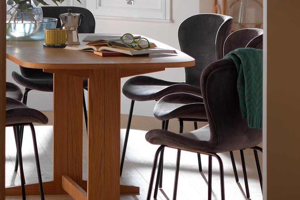 Oak extending dining table with grey velvet dining chairs.