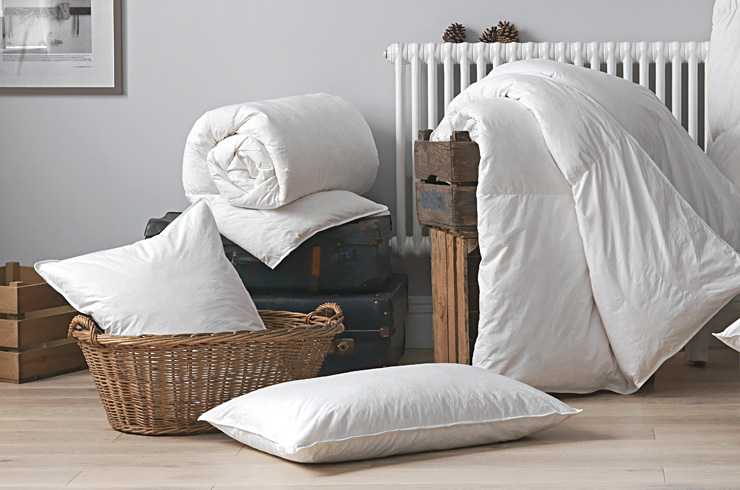 Duvet and pillows placed in a basket and on the floor.