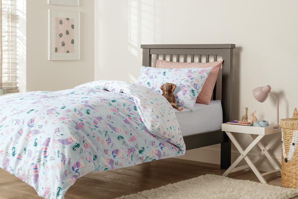 Image of a toddler size bed with an ocean theme bedding.