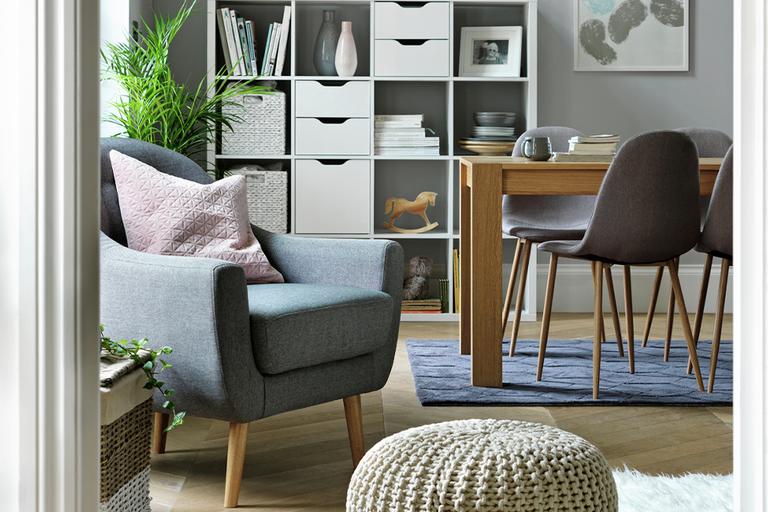 Image of a living-dining set up with a storage unit in the background.