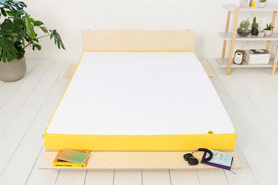 Mattress on wooden bed frame in bedroom.