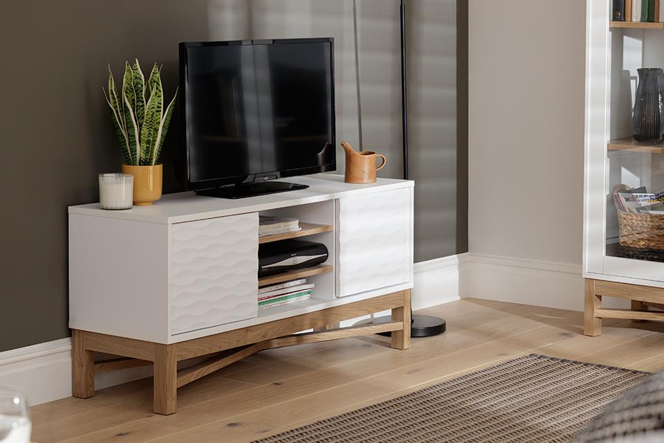 Image of a white TV stand in a grey living room.