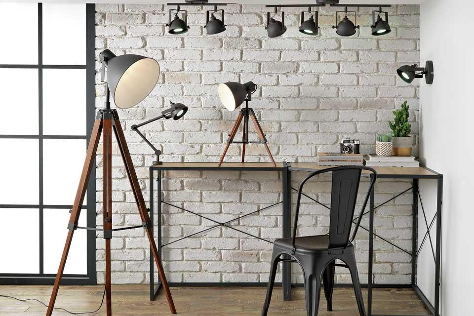 An industrial style home office with a floor lamp, table lamps and spotlights.