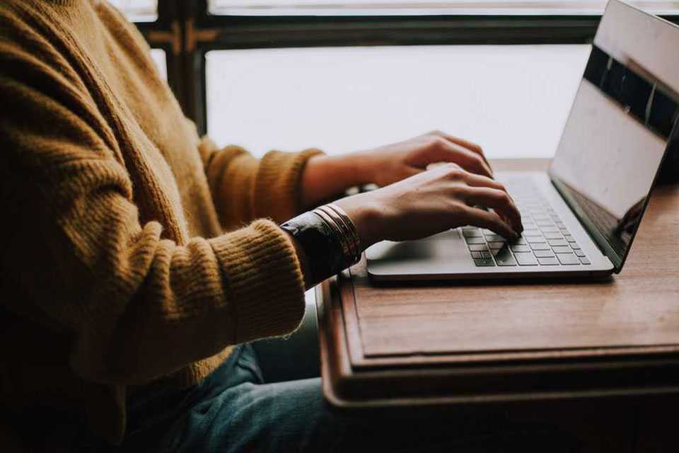 Person typing on laptop.