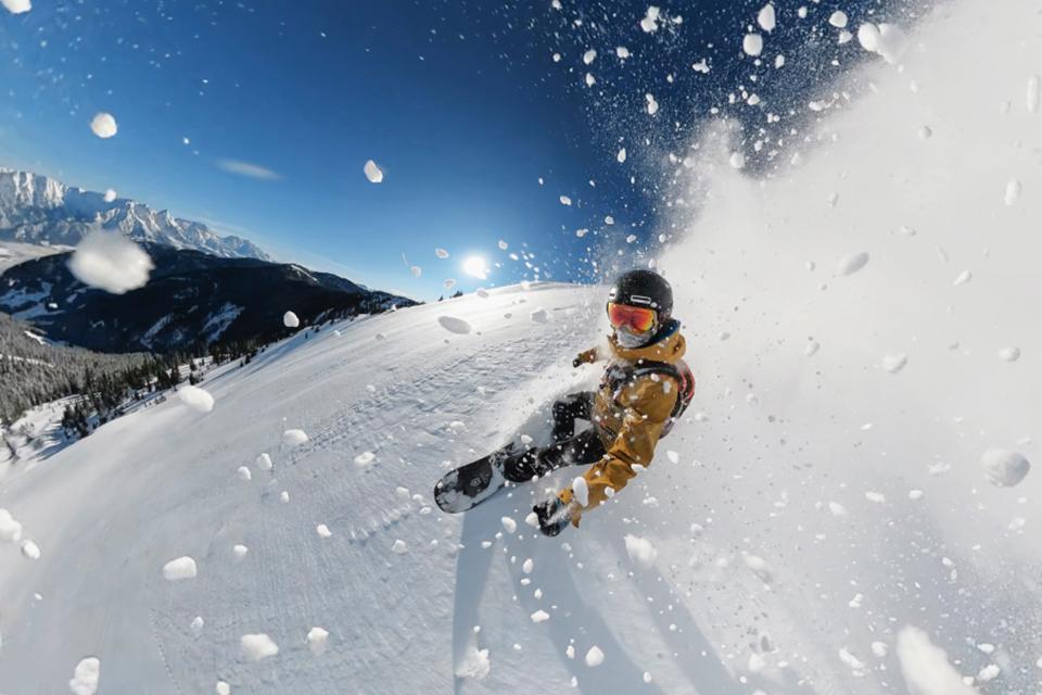 A man taking a selfie while snowboarding.