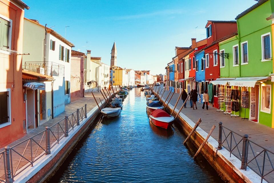 A canal with boats and narrow pathways on both sides.
