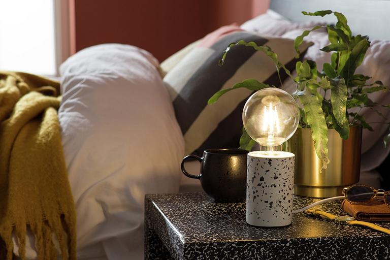 An Argos Home dash exposed bulb lamp on a bedside table.