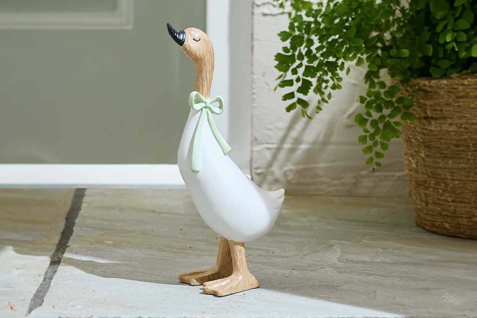 Home duck ornament placed outdoors on a patio.