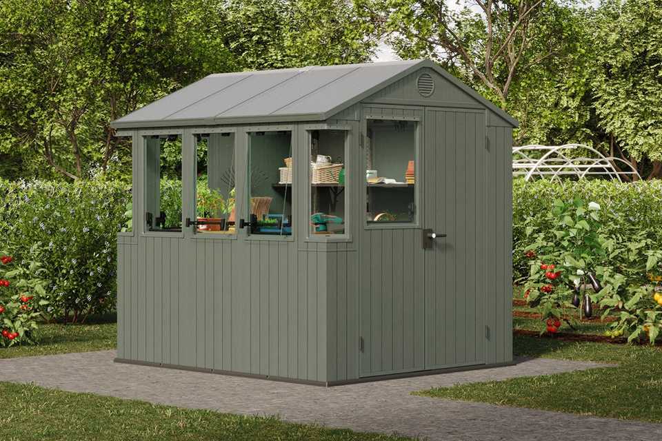 Keter Darwin potting shed in green colour placed outdoors.