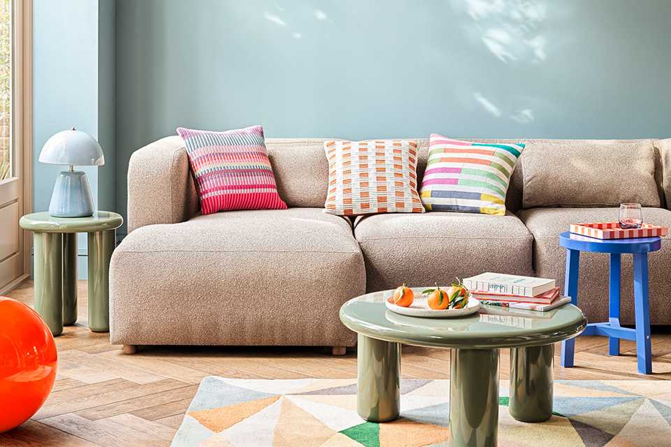 A living room with a chunky sofa, a coffee table and a blue side table.