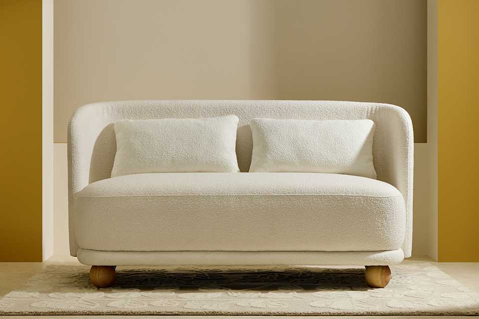 Habitat Poppy Fabric 2 Seater Sofa in natural finish placed in a living room on a rug.