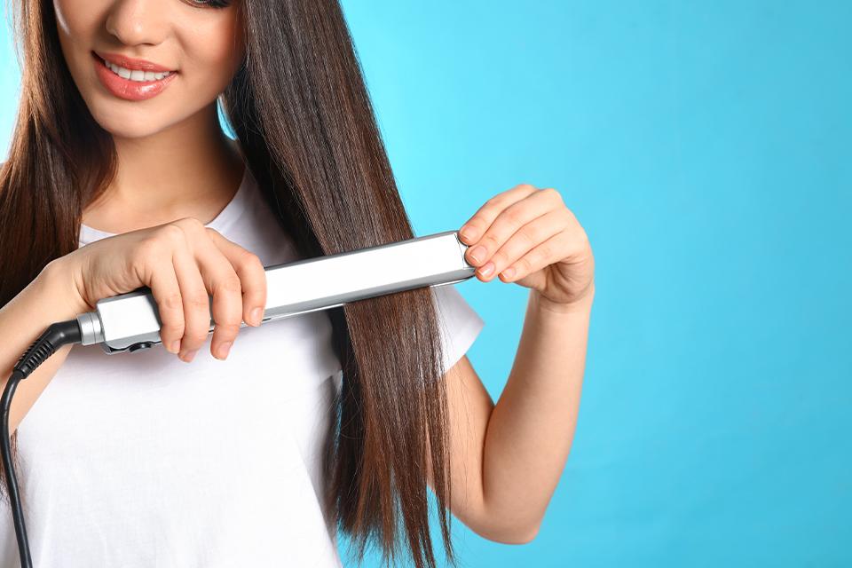 A lady straightening her hair.