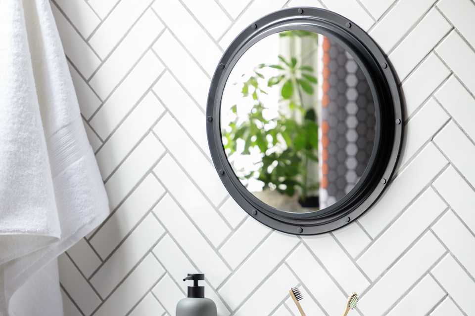 Black circle mirror in bathroom.