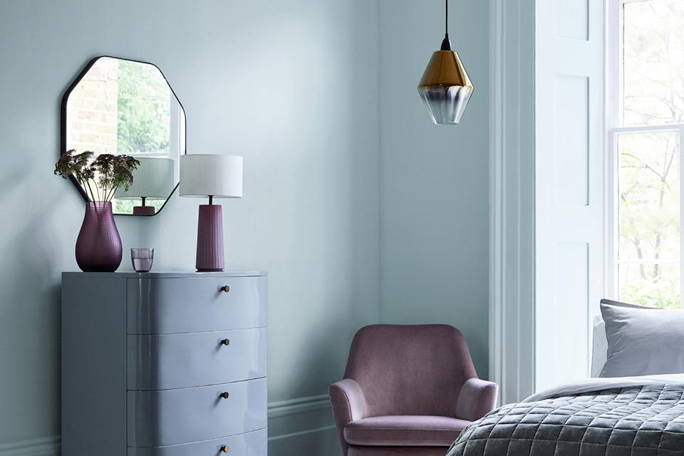 Mirror above chest of drawers in bedroom.