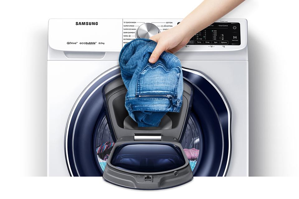 Adding clothes to washing machine through add wash door whilst running.