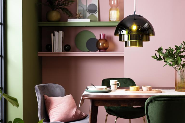 Terrazzo dining table with green and pink velvet chairs.
