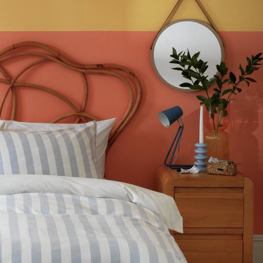 A wooden bed with blue and white striped bedding.