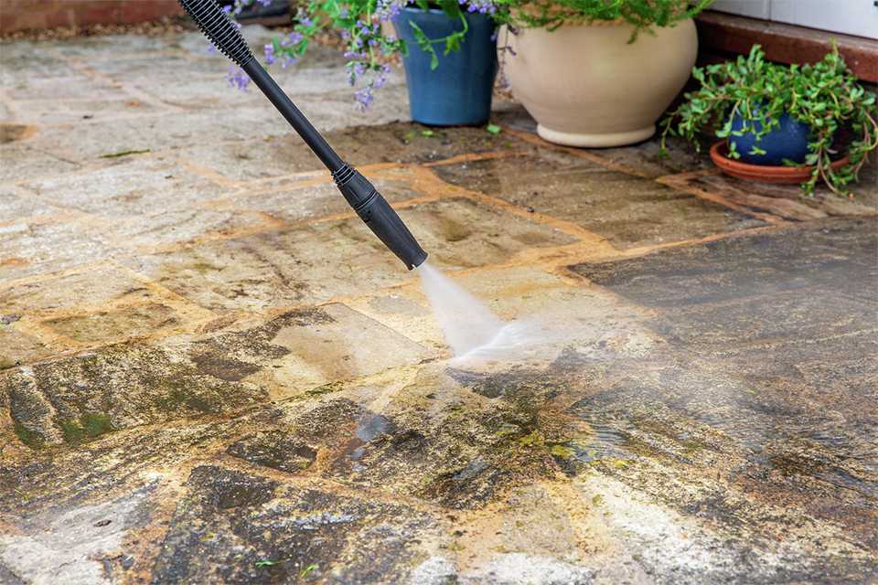 A floor being cleaned with a pressure washer with a dirtblaster lance.