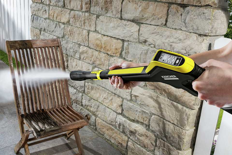 A person using a pressure washer with a pressure adjustable lance.
