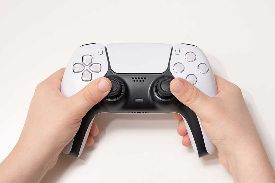 Hands holding a PS5 controller.