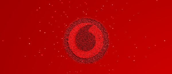 An ariel view of lots of bright red balloons appearing to create the Vodafone logo.