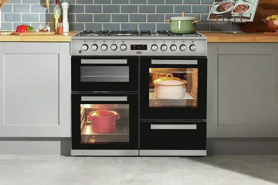 Three pots on and in a Beko KDVF100X 100cm Dual Fuel Range Cooker - Stainless Steel.