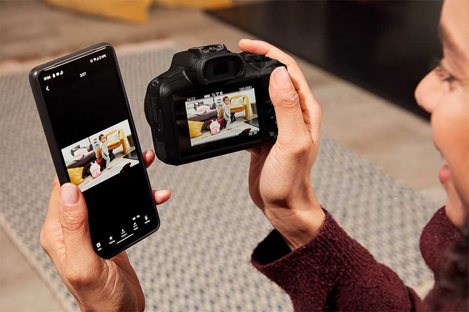A person using Canon Camera Connect app to connect camera with smart phone.
