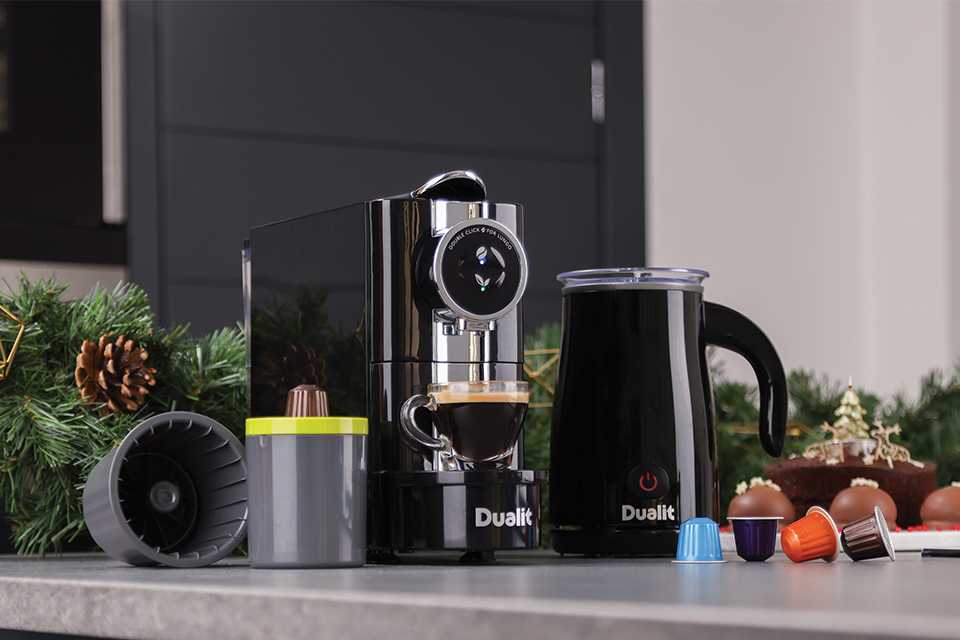 A Dualit Café Plus coffee machine, EcoPress™ capsule recycler and milk frother with coffee capsules.