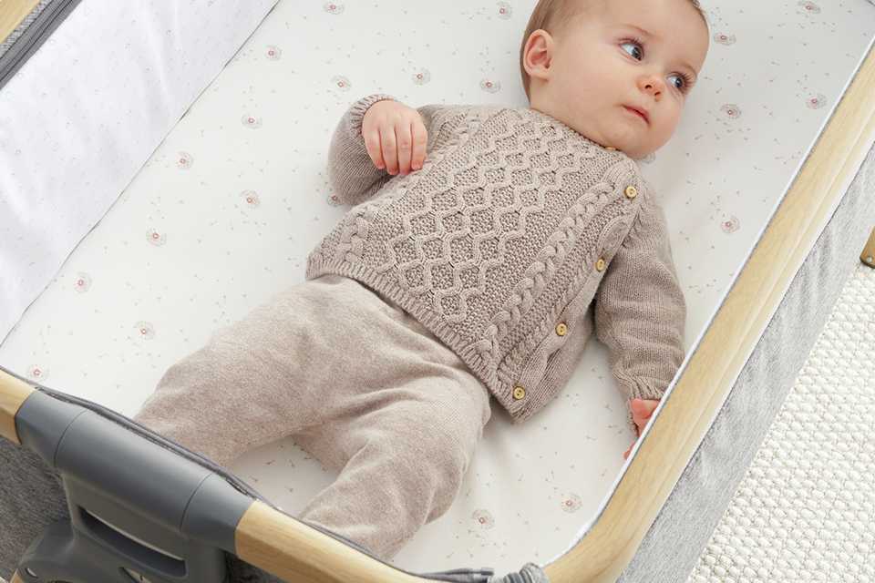 A baby sleeping on Tutti Bambini Cozee Crib 2pk Fitted Sheets Cocoon.