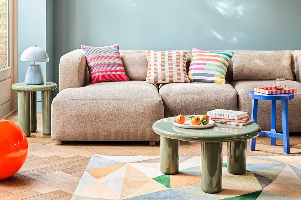 A Habitat sofa placed in a living room with multicoloured cushions on it.