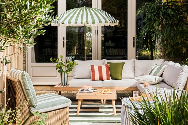 Habitat Wooden Garden Sofa Set places outdoors with stripes cushions on it and a wooden coffee table in front of it.