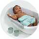A baby in an Ingenuity 4 in 1 Room To Soak Tub Baby Bath.